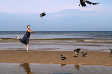 Baltık Denizi, kumsalda yürüyüş ve b besleme koyu saçlı kadın