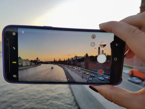 El bir fotoğraf şehir smartphone günbatımı al. Üzerinde