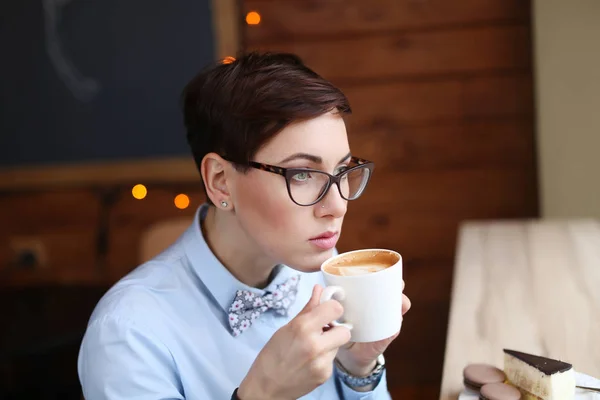 Joven hermosa mujer, trabajador de oficina en gafas, fue a la cafetería para un descanso de café, laico, beber café —  Fotos de Stock