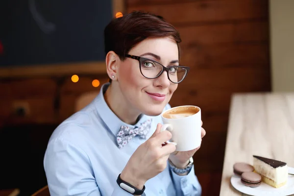 Joven hermosa mujer, trabajador de oficina en gafas, fue a la cafetería para un descanso de café, laico, beber café —  Fotos de Stock