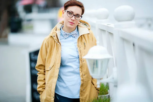 Young beautiful woman  in glasses, short fashionable hairstylein in office clothes, jacket, walking through the streets, spring walks — Stock Photo, Image
