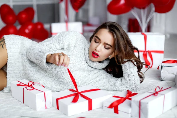 Jonge sexy vrouw met make-up en kapsel, met cadeautjes en ballonnen — Stockfoto