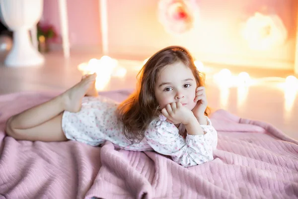 Menina Posando Deitado Xadrez Rosa Com Luzes Fundo — Fotografia de Stock