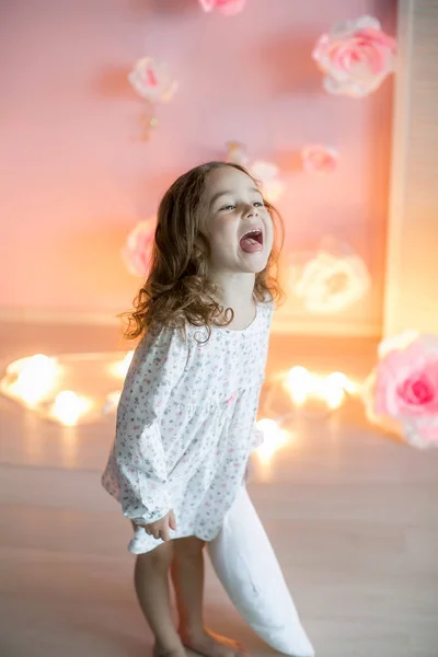 Malá Dívka Pózuje Výrazem Obličeje Drží Bílý Polštář Osvětlením Pozadí — Stock fotografie