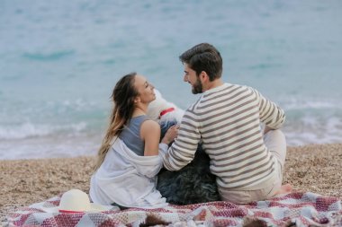 Hasır şapka ve sakallı adam eğleniyor genç kadın tüylü köpekle oynamayı