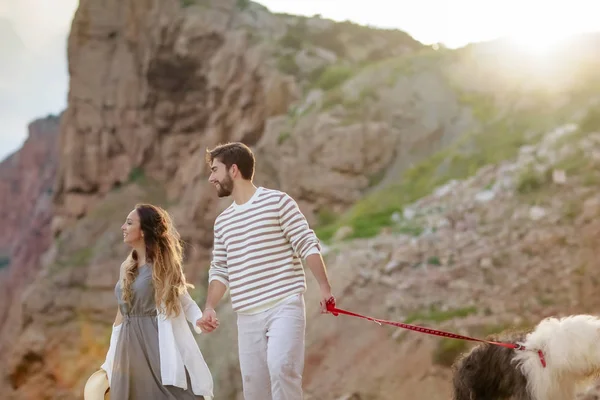 Media Longitud Feliz Pareja Cogida Mano Caminando Con Perro Esponjoso —  Fotos de Stock