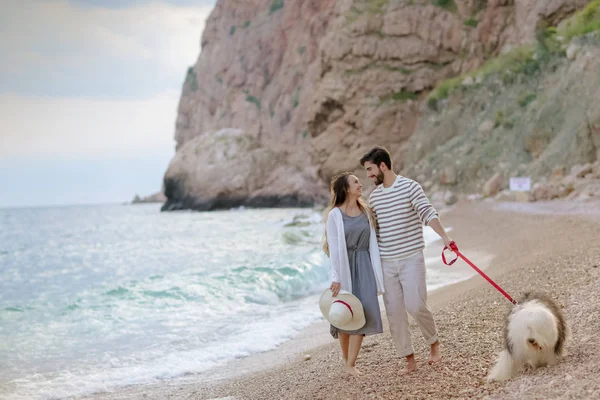 Teljes Hosszúságú Fiatal Pár Átölelve Urai Pihés Kutya Strandon — Stock Fotó