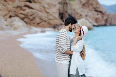 yakışıklı adam kucaklayan güzel kız beyaz şapka birlikte daimi deniz kıyısında