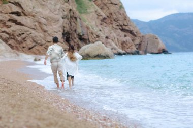 mutlu genç çiftin birlikte deniz kıyısında, geri görünüm çalışan eğleniyor tam uzunlukta