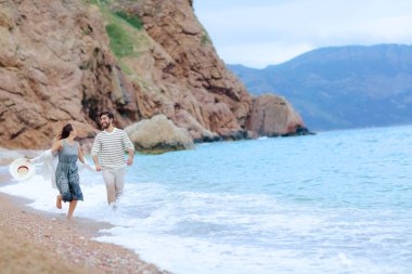 mutlu genç çiftin birlikte deniz kıyısında çalışan eğleniyor tam uzunlukta