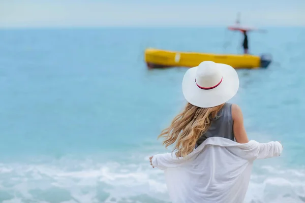 Νεαρή Γυναίκα Μακριά Σγουρά Μαλλιά Στέκεται Στην Παραλία Βλέπει Βαρκών — Φωτογραφία Αρχείου