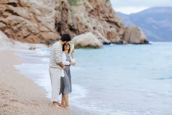 海の岸に立っているを抱き締める素朴な服でスタイリッシュな若いカップルのロマンチックな瞬間 — ストック写真