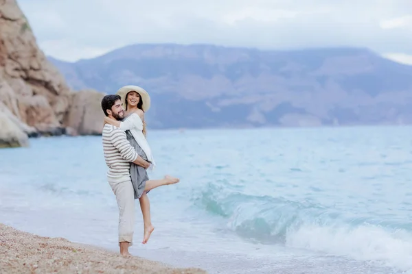 Feliz Hombre Abrazando Levantando Hermosa Mujer Pie Playa Con Acantilado — Foto de Stock