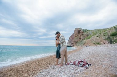 mutlu genç bir çift deniz sahilde, tam uzunlukta poz sarılma