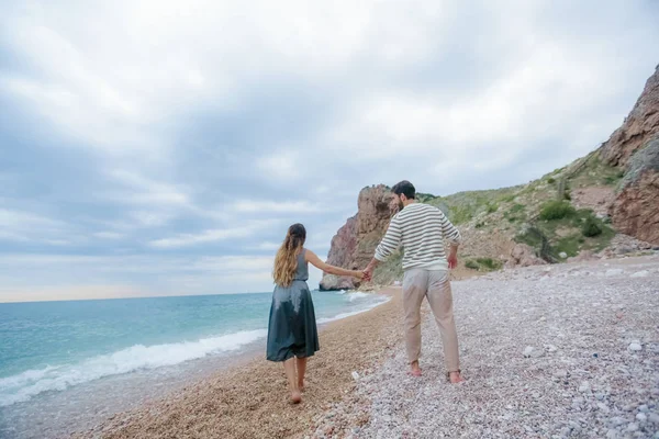 フルの長さ 手をつないで海ビーチの上を歩く若いカップル — ストック写真