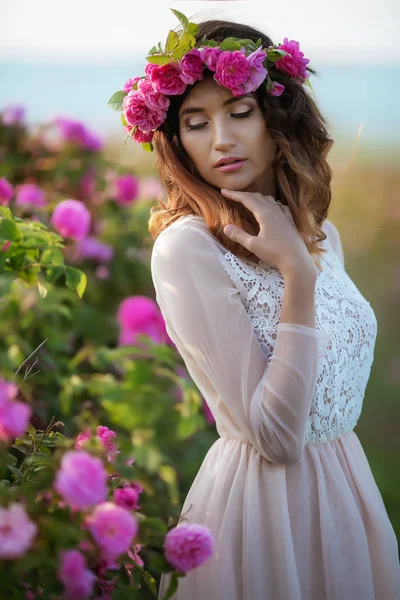 緑の自然の背景に長いドレスと花の花輪立っている女性 — ストック写真