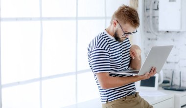 laptop ayakta ofiste çalışan genç yakışıklı işadamı