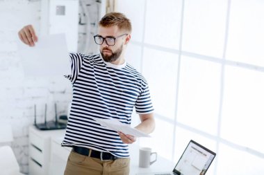 genç yakışıklı işadamı ofiste duran kağıtları kontrol