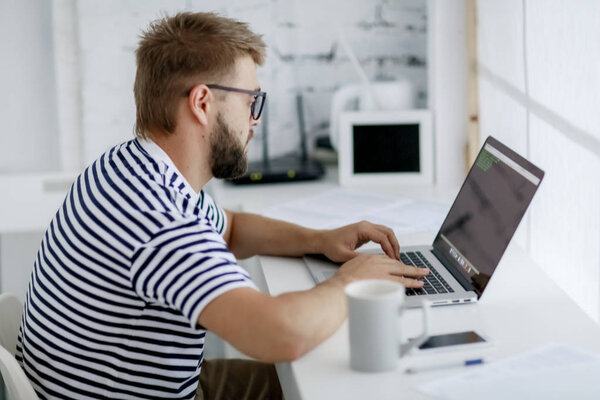 young handsome businessman working on laptop sitting at desk