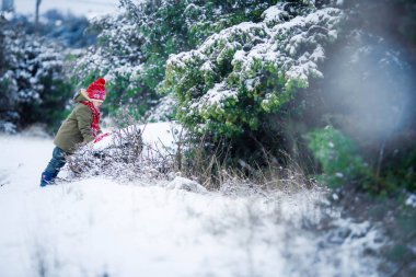mutlu küçük çocuk eğleniyor tam uzunlukta kar ile oynamak
