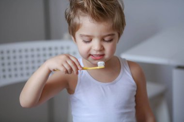 komik küçük çocuk portresi diş fırçası tutan ve dişlerini Temizleme