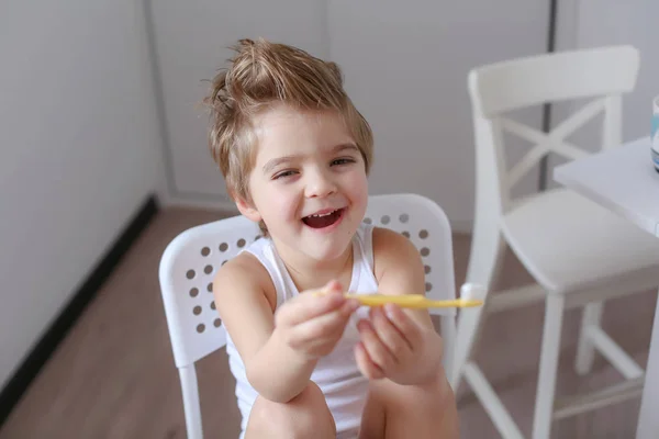 Retrato Niño Divertido Sosteniendo Cepillo Dientes Sonriendo Sentado Silla Blanca — Foto de Stock