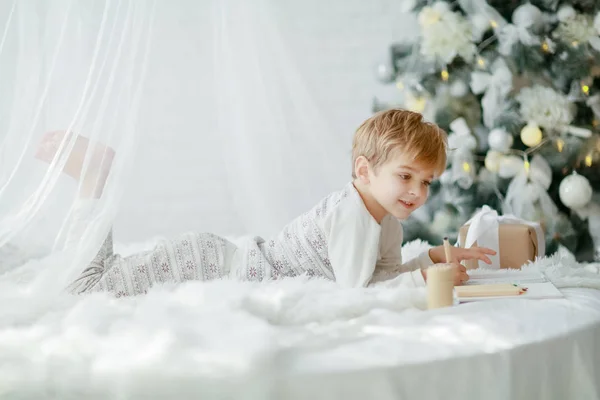 Повна Довжина Маленького Хлопчика Лежить Білому Ліжку Біля Прикрашеної Ялинки — стокове фото