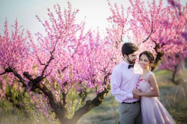 güzel gelin ve damat Bahçe çiçek açması ağaçlar karşı poz 