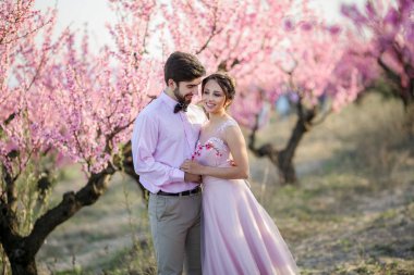 güzel gelin ve damat Bahçe çiçek açması ağaçlar karşı poz 