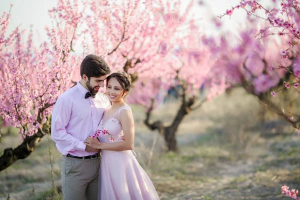 美しい花嫁と新郎に対して開花木庭でポーズ — ストック写真