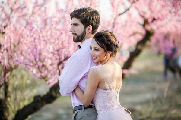 Vackra Bruden Och Brudgummen Poserar Trädgården Mot Blommande Träd — Stockfoto