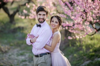 güzel gelin ve damat Bahçe çiçek açması ağaçlar karşı poz 