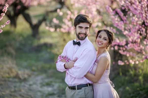 Vackra Bruden Och Brudgummen Poserar Trädgården Mot Blommande Träd — Stockfoto