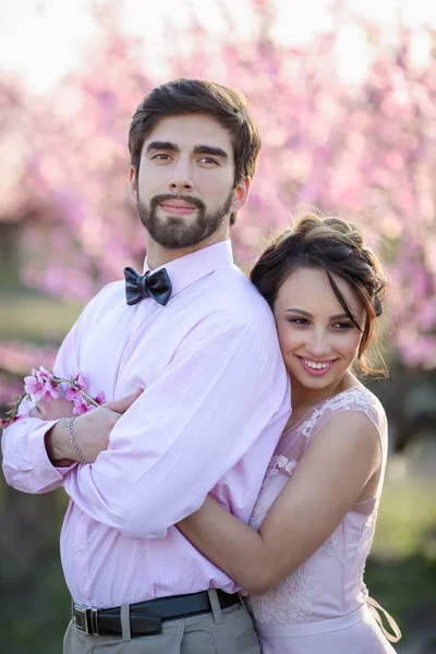 Vackra Bruden Och Brudgummen Poserar Trädgården Mot Blommande Träd — Stockfoto