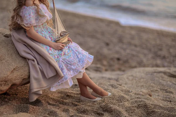 Vacker Blond Flicka Holding Träleksak Fartyget Stående Stranden Vid Solnedgången — Stockfoto