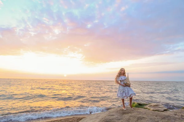 Schönes Blondes Mädchen Mit Holzspielzeugschiff Das Bei Sonnenuntergang Ufer Des — Stockfoto