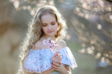 güzel sarışın kız çiçek açması bahçede poz mavi elbise 