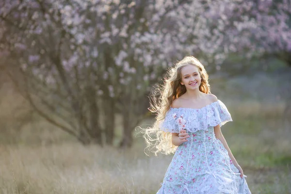 Mooie Blonde Meisje Poseren Bloeiende Tuin Draagt Blauwe Jurk — Stockfoto