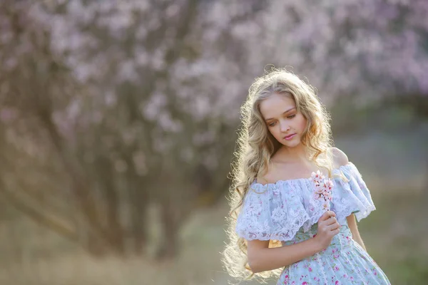 Młoda Piękna Blondynka Pozowanie Kwitnących Ogród Sobie Niebieską Sukienkę — Zdjęcie stockowe