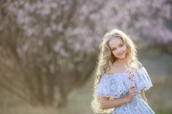 Fiatal Gyönyörű Szőke Lány Pózol Kék Ruhát Visel Virágzó Kert — Stock Fotó