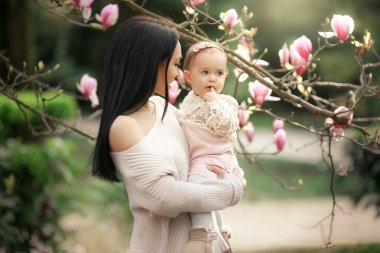 güzel anne ve kızı çiçek açan bahçede poz 