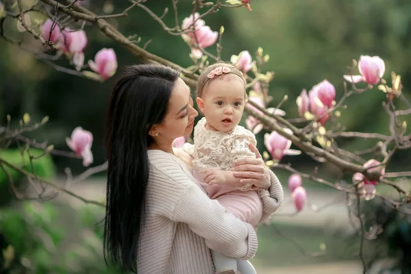 美丽的母亲和女儿摆在盛开的花园里 — 图库照片