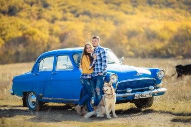 iki sevgi ve husky köpek mavi arabanın yakınında poz sonra 