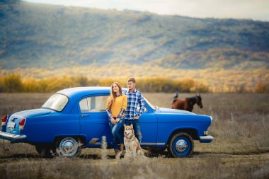 iki sevgi ve husky köpek mavi arabanın yakınında poz sonra 