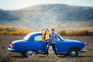 iki sevgi ve husky köpek mavi arabanın yakınında poz sonra 