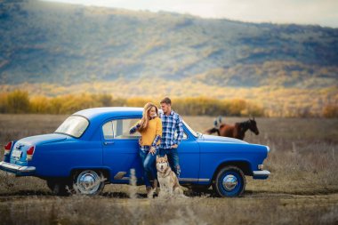 iki sevgi ve husky köpek mavi arabanın yakınında poz sonra 