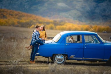 iki sevgi ve husky köpek mavi arabanın yakınında poz sonra 