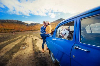 iki sevgi ve husky köpek mavi arabanın yakınında poz sonra 