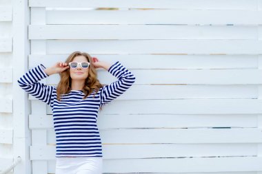 çizgili gömlekli ahşap arka plan karşı poz genç güzel kadın