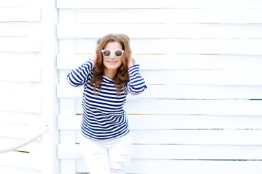 çizgili gömlekli ahşap arka plan karşı poz genç güzel kadın
